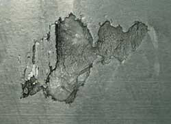 Contact fatigue spalling on a cylindrical inner race resulting from isolated surface damage.